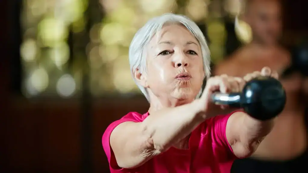 Older woman doing weight training Sutton Coldfield to help her strength and longevity 
