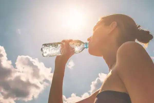 Hydration: The Secret Ingredient for a Toned Stomach and Enhanced Fitness 3 Image of woman drinking water to hydrate Sutton Coldfield after run.