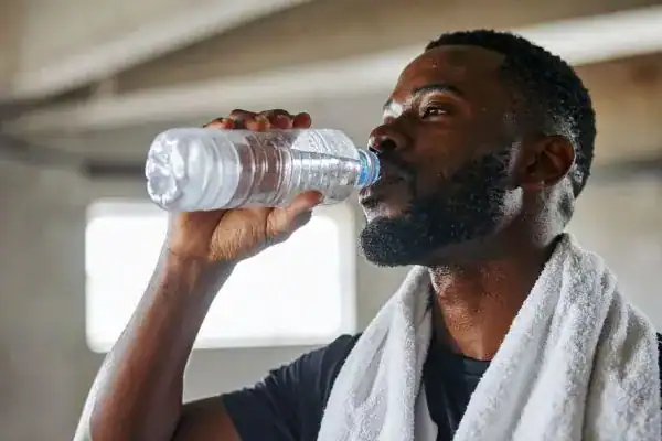 Hydration: The Secret Ingredient for a Toned Stomach and Enhanced Fitness 1 Image of man drinking water to improve hydration Sutton Coldfield after work out.